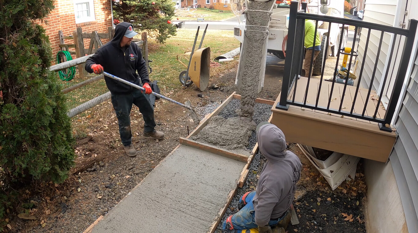 Workers installing concrete walkway and stairs with wooden forms in Bradenton, FL